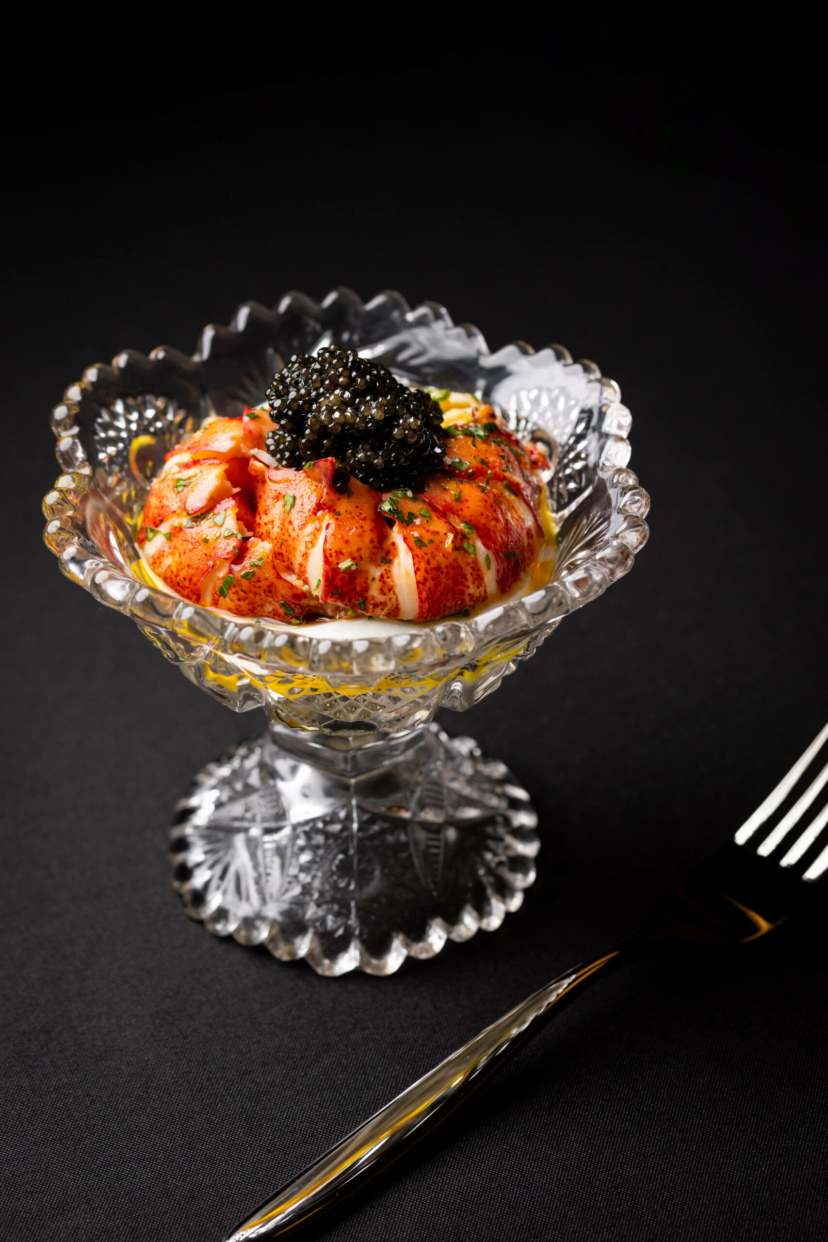 A close-up view of the dish served with a gold fork, emphasizing the refined presentation.