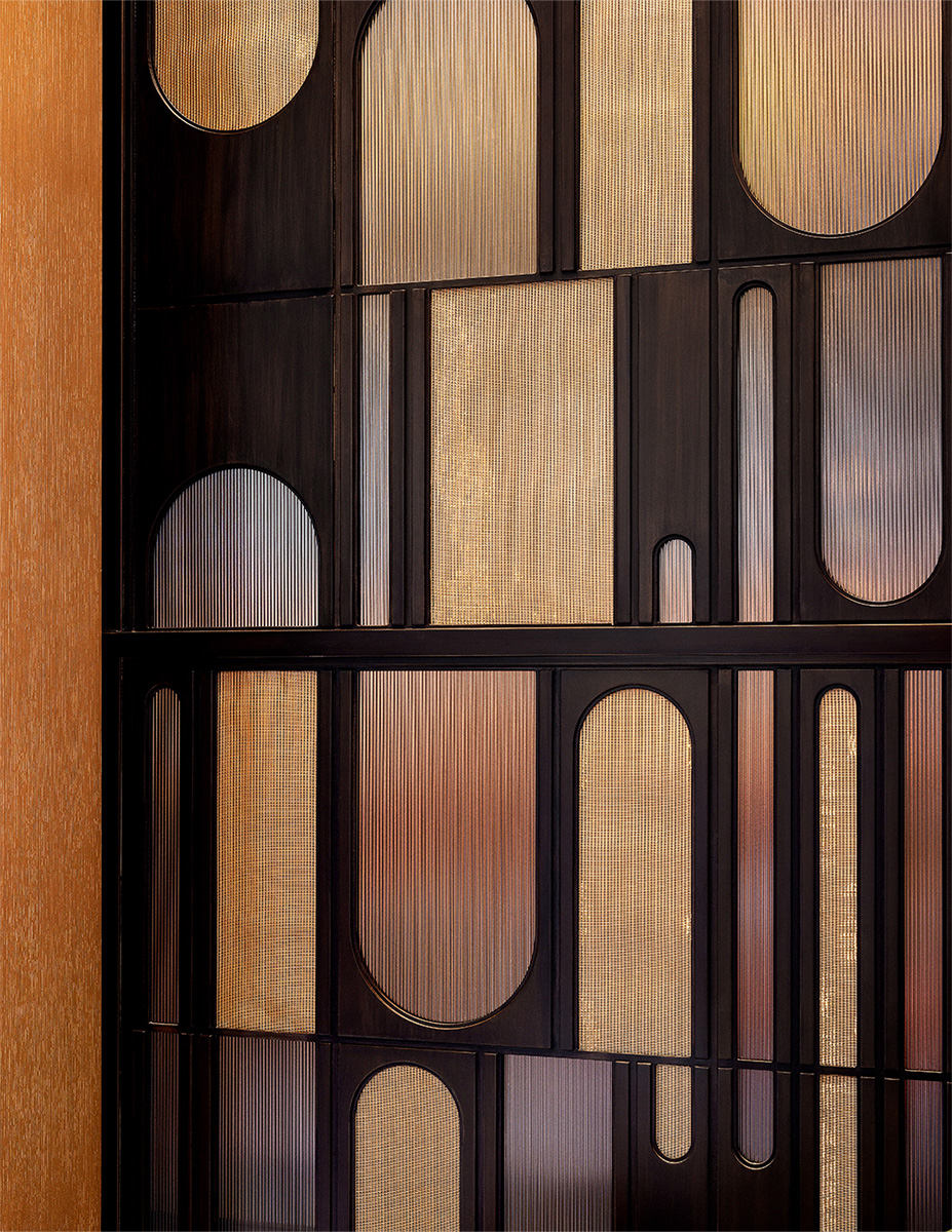 Decorative geometric wall panel in dark metal and gold tones, adding texture to the interior.